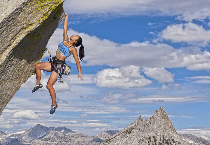 攀岩在悬崖边上的女攀岩运动员