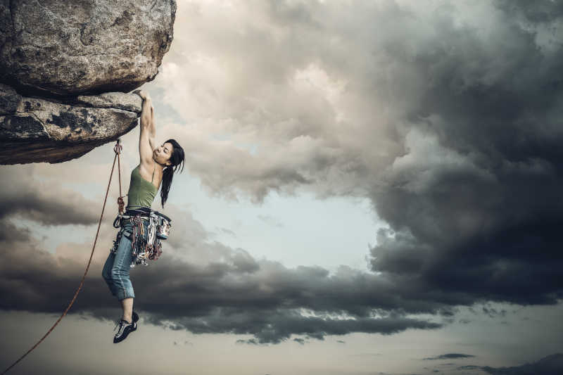 女登山者悬挂在悬崖边的一个挑战
