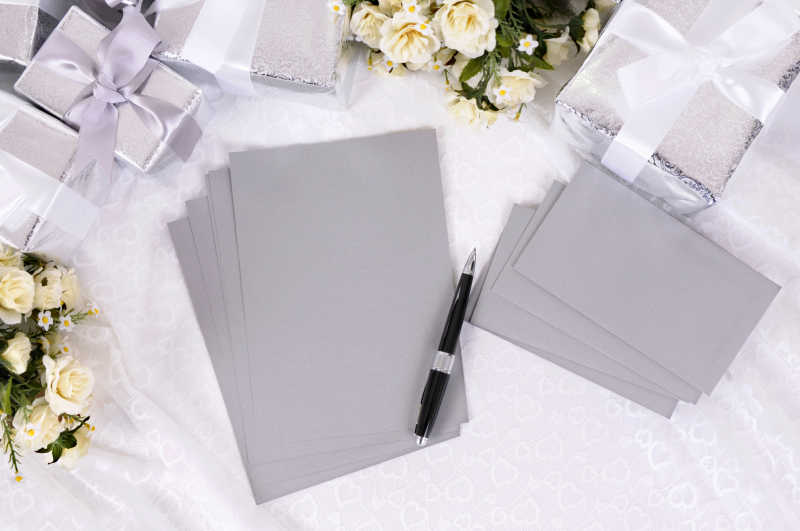 银灰色信纸旁边的婚礼用礼品