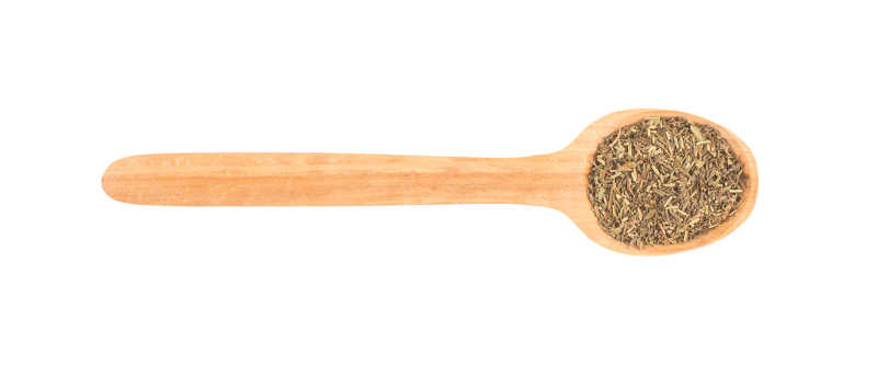 白色背景下的木制汤勺中的普罗旺斯草药