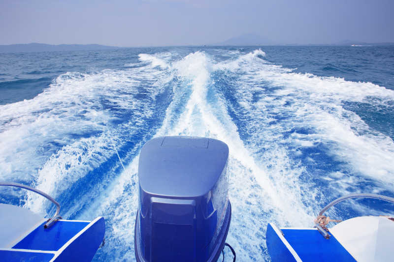 游艇在蓝色海面上高速行驶后产生的特写