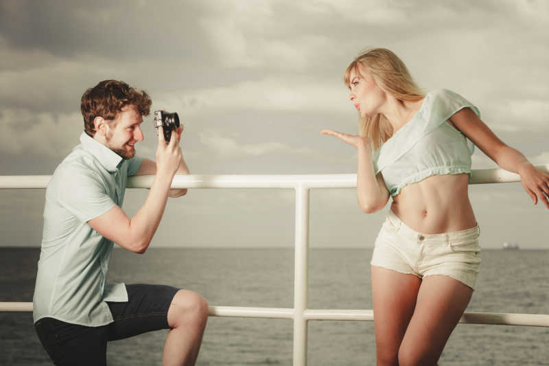 相爱年轻情侣在码头拍照