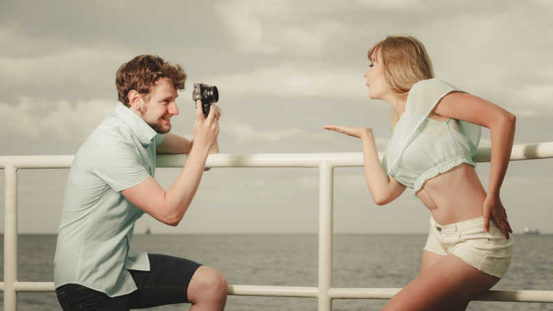 相爱年轻情侣在码头上拍照