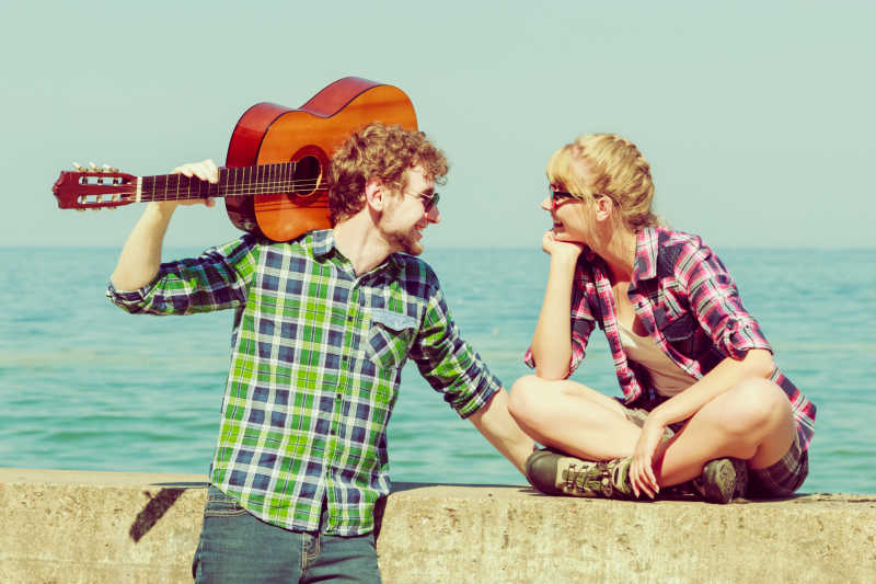 海边给女朋友弹吉他的年轻人
