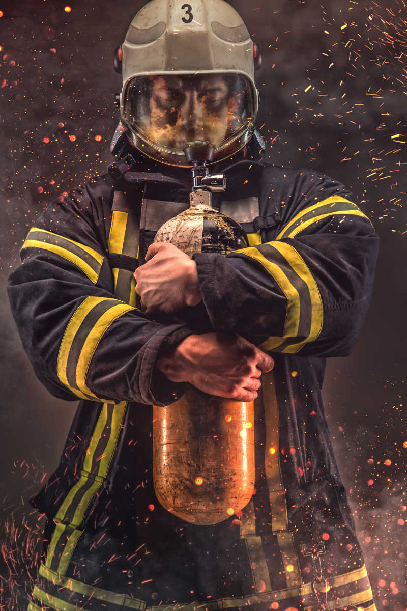 戴头盔和面罩的消防员手持氧气罐