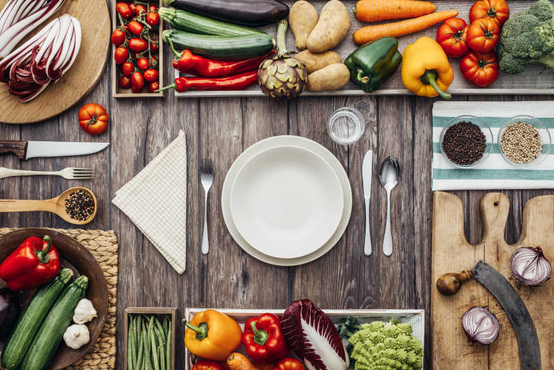 新鲜健康的蔬菜砧板和炊具构成一个老式厨房台面框架