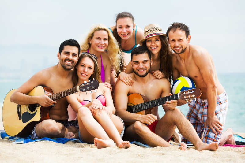 成年人在海滩上玩吉他