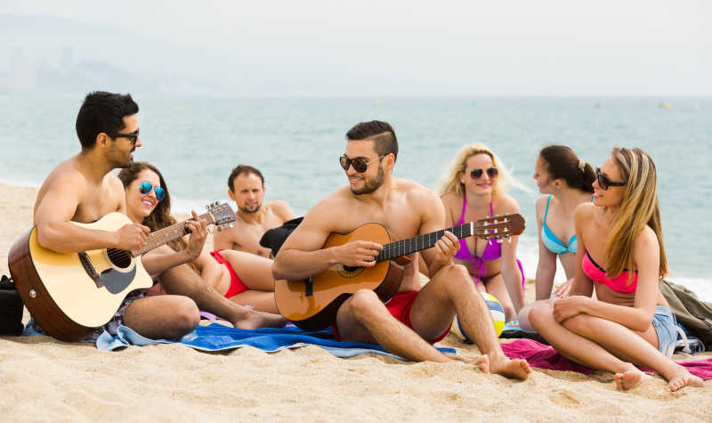 成年人在沙滩上弹吉他