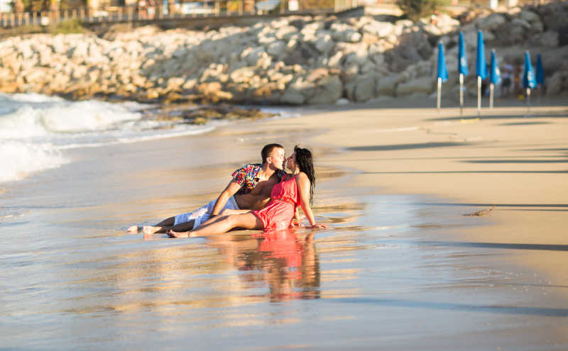 年轻多情的情侣在沙滩上接吻