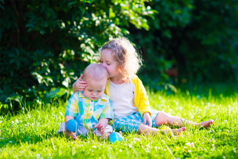 夏季花园里小女孩拥抱小男孩