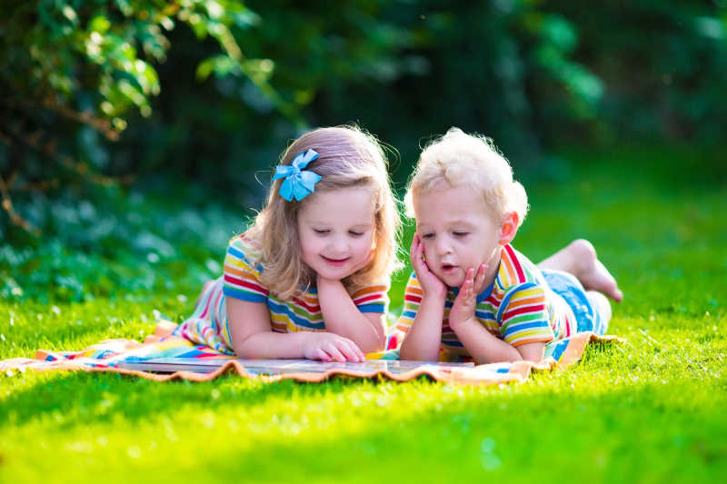 在夏日花园里读书学习的两个孩子