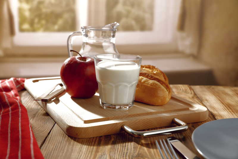 桌上的新鲜牛奶苹果和面包