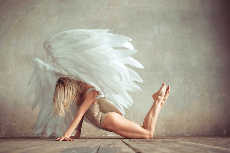 趴着地上双脚抬起跳舞的天使舞者