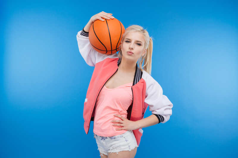 把篮球抱在肩上的漂亮女孩