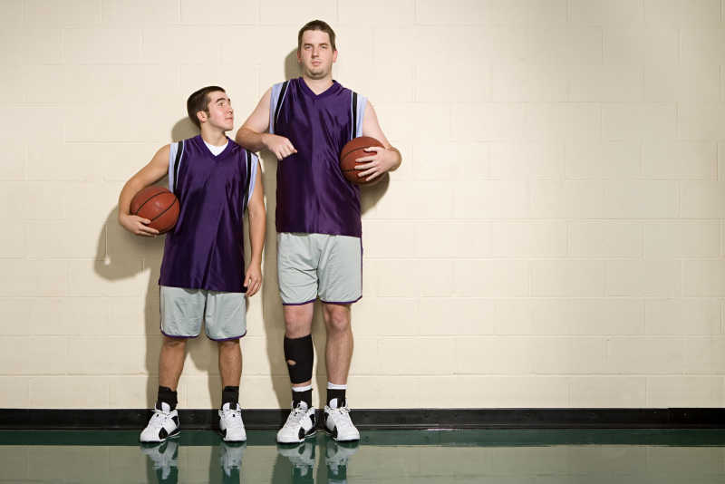 高的和矮的篮球运动员抱着篮球