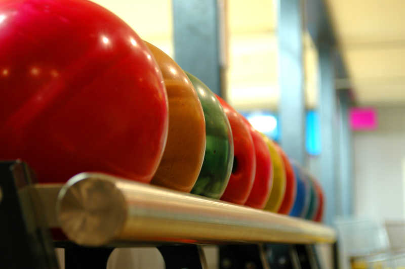 栏杆上摆放整齐各种颜色的保龄球
