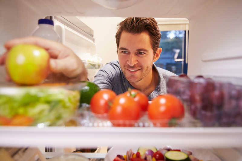男子在冰箱里寻找苹果
