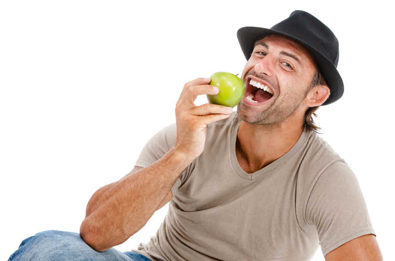 笑着吃青苹果的男子