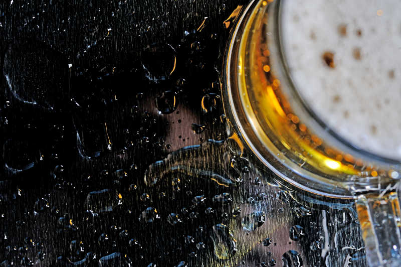 桌子上溢出啤酒的杯子