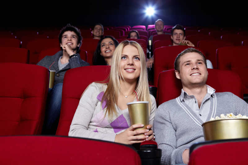一群年轻人面带微笑地看电影