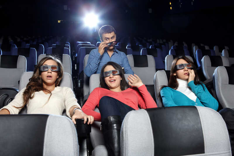 一群年轻人戴着3D眼镜看电影