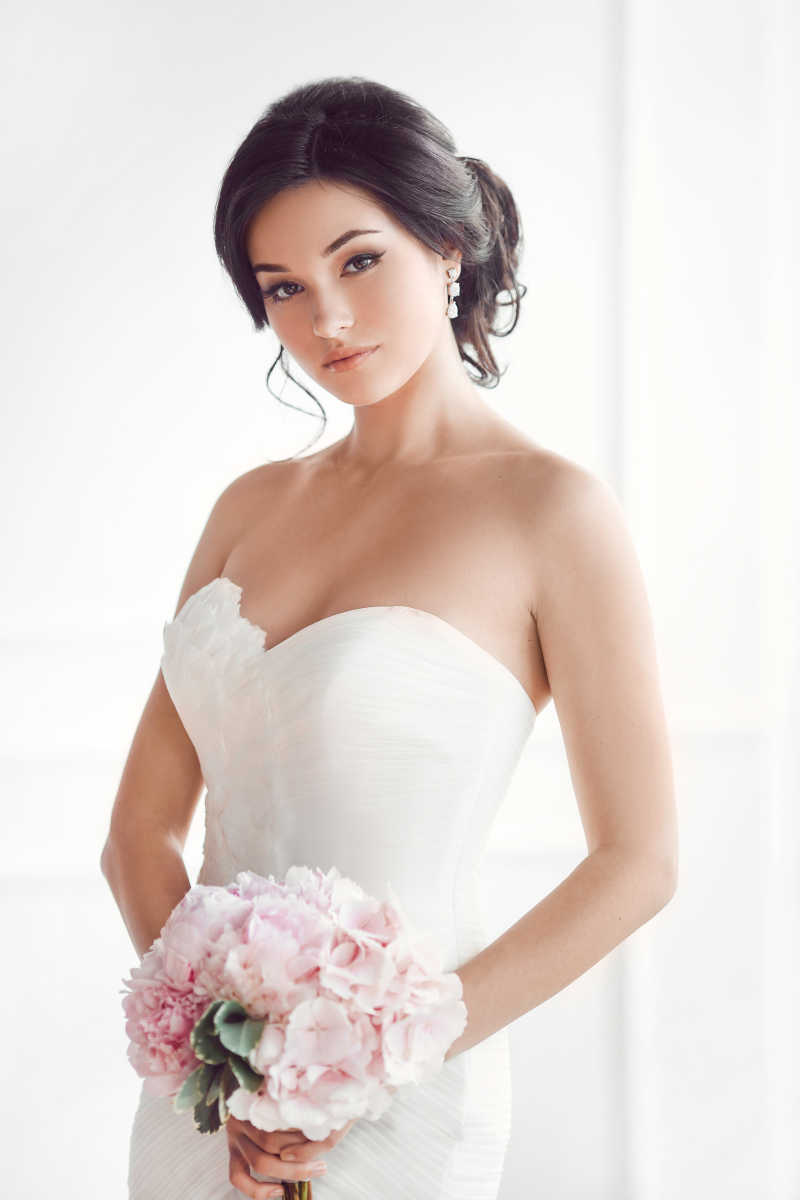 新娘穿着婚纱手捧粉色花束