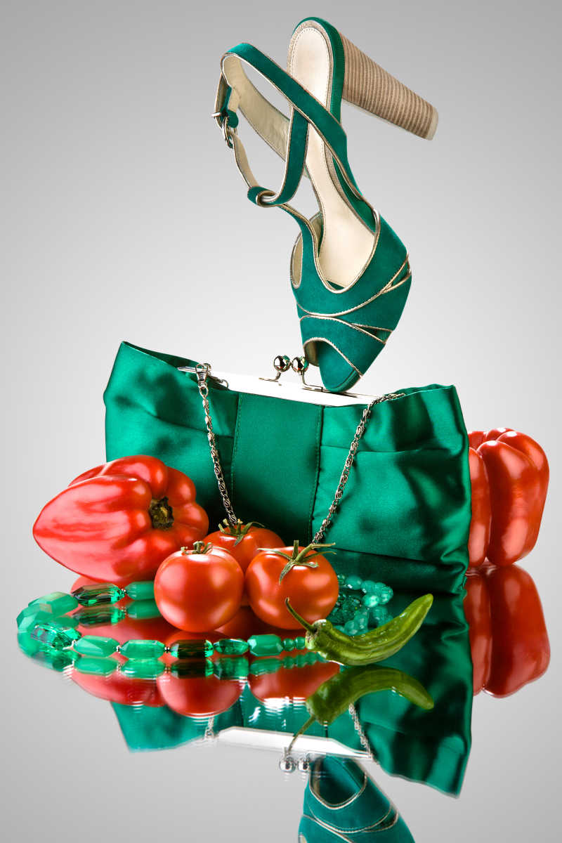 一个绿色手提包高跟鞋珠子和蔬菜的特写镜头