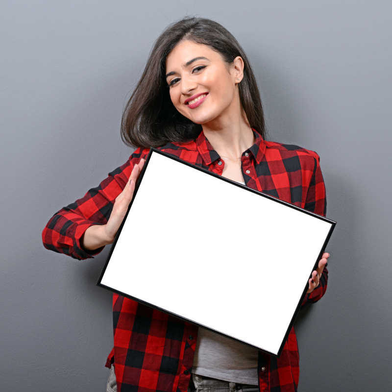 一个面带微笑的女人拿着空白的标志牌