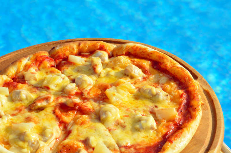 游泳池背景的美味芝士披萨