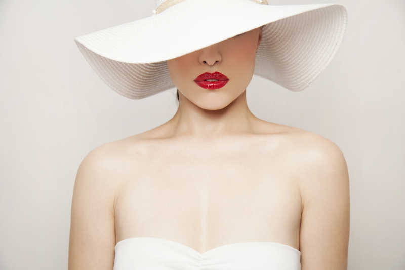 女人的美丽画像与红唇和夏季白帽子