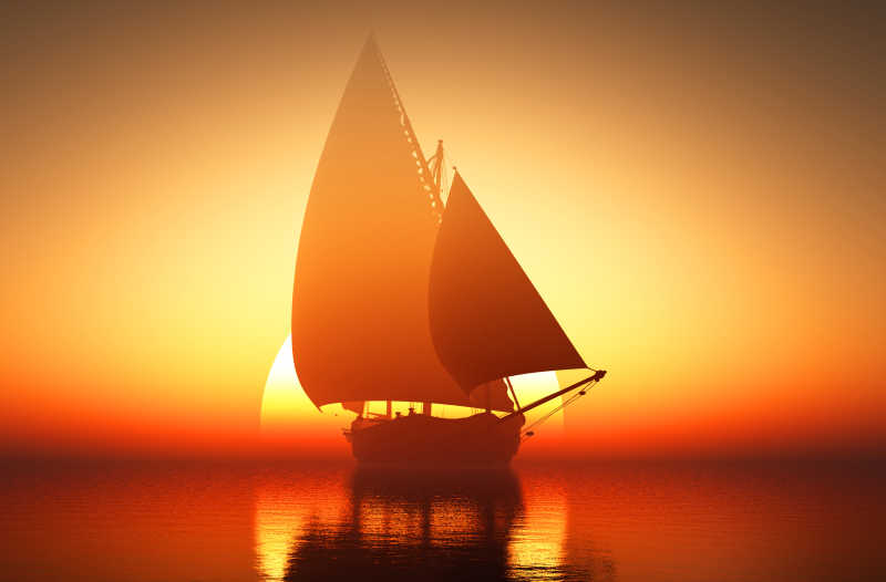 夕阳下扬帆前行的帆船