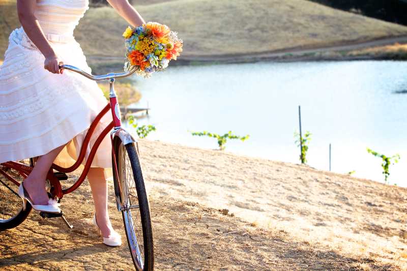 新娘骑着自行车手拿花束