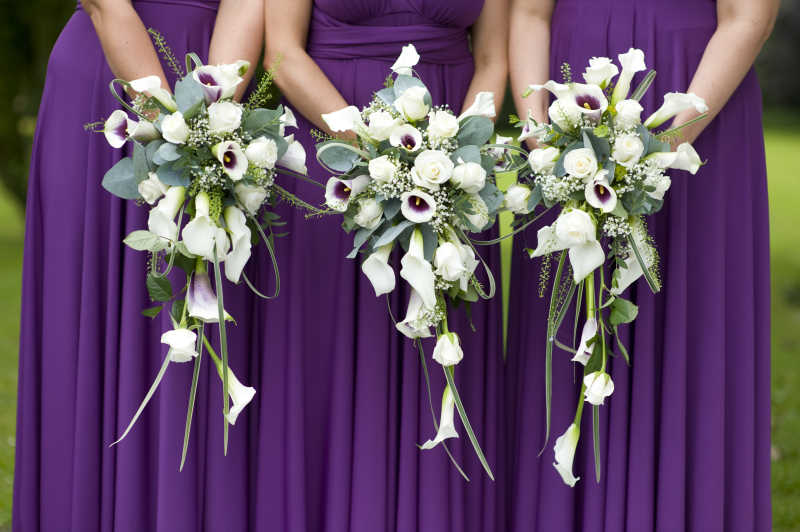 紫色礼服的伴娘拿着鲜花