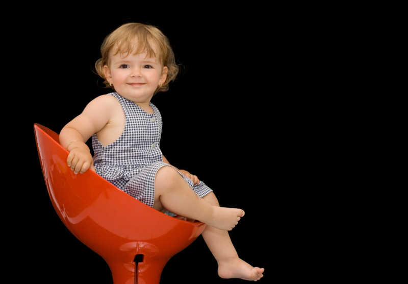 小女孩坐在椅子上微笑