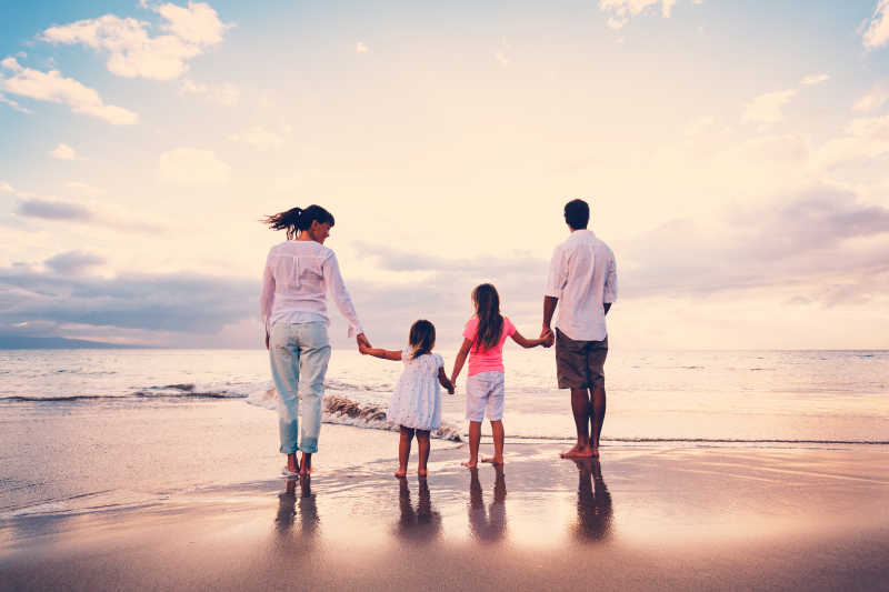 海滩上度假的一家人背影