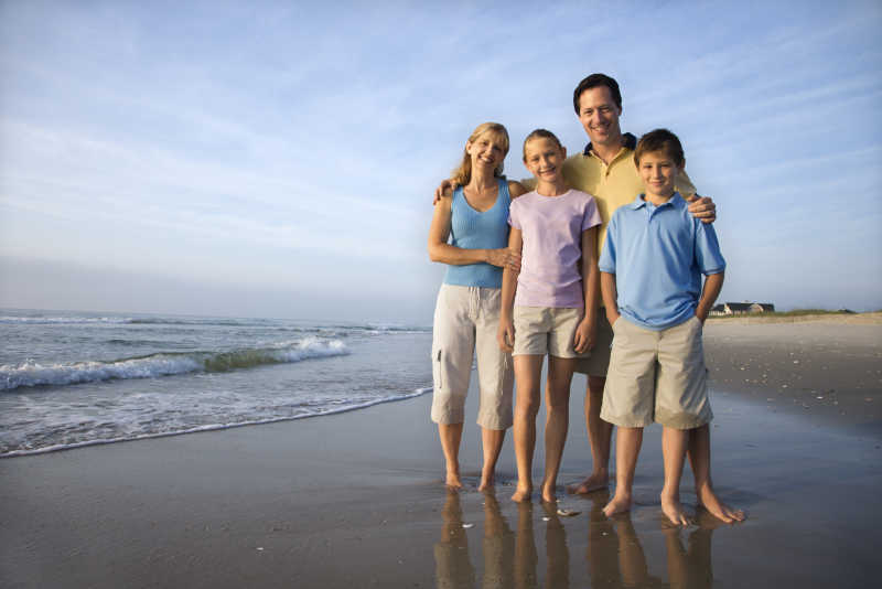 假日度假的一家人在海滩上合影