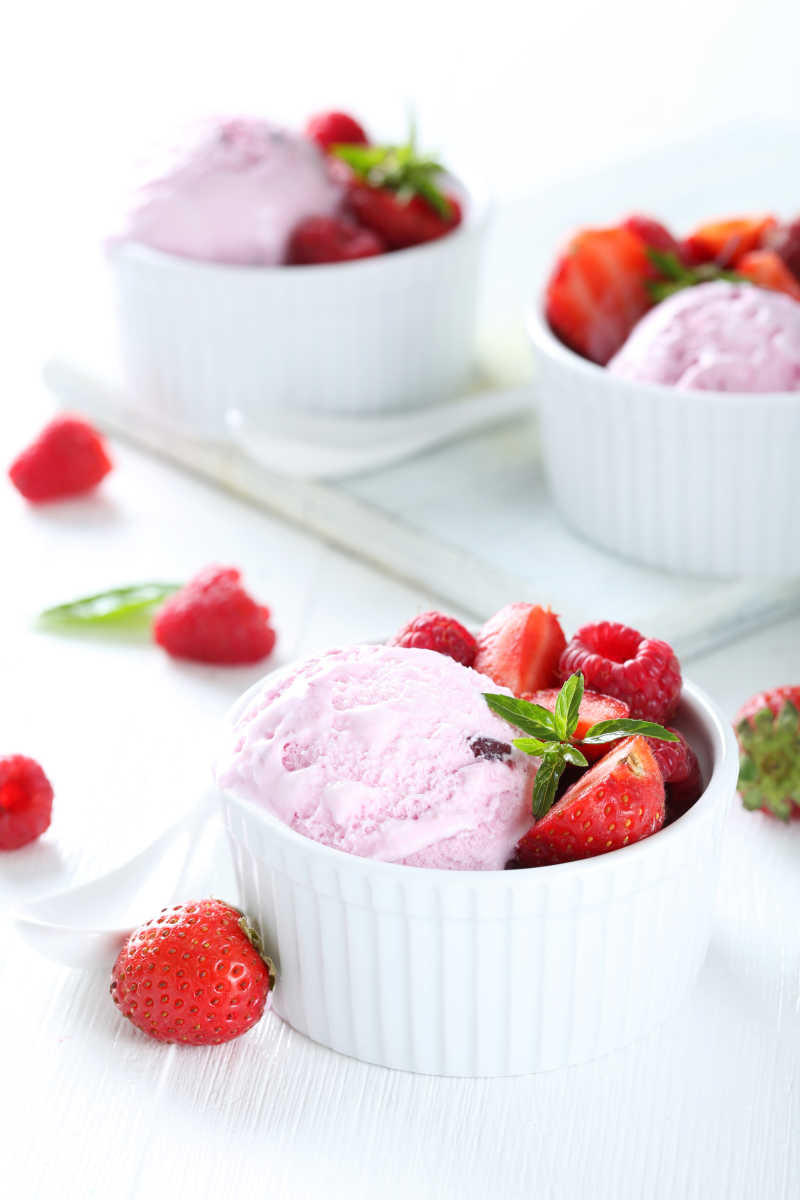 在白木背景下的草莓冰淇淋和覆盆子