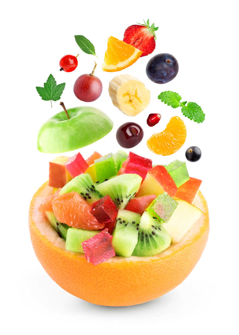 新鲜的水果被切成块落在橙子做的碗里