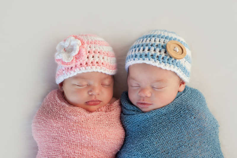 穿着不同颜色的睡着的双胞胎宝宝