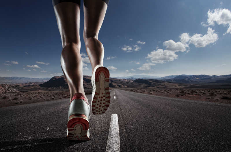 在道路上跑步的运动员的脚和鞋