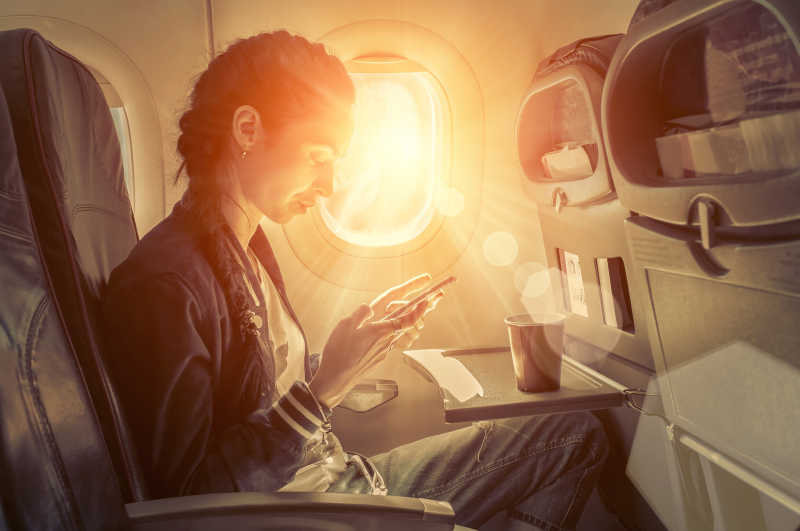 坐在飞机上看手机的女人