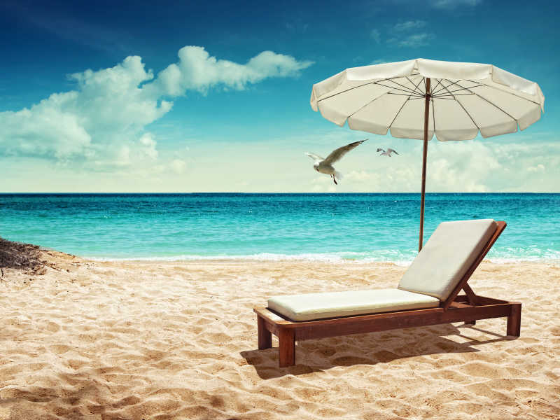 热带沙滩下的白色躺椅
