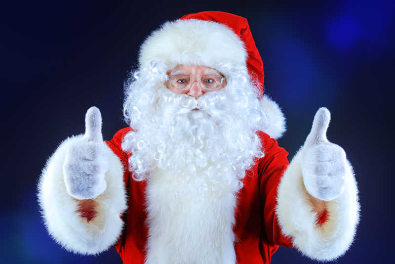 黑色背景下竖起大拇指的圣诞老人