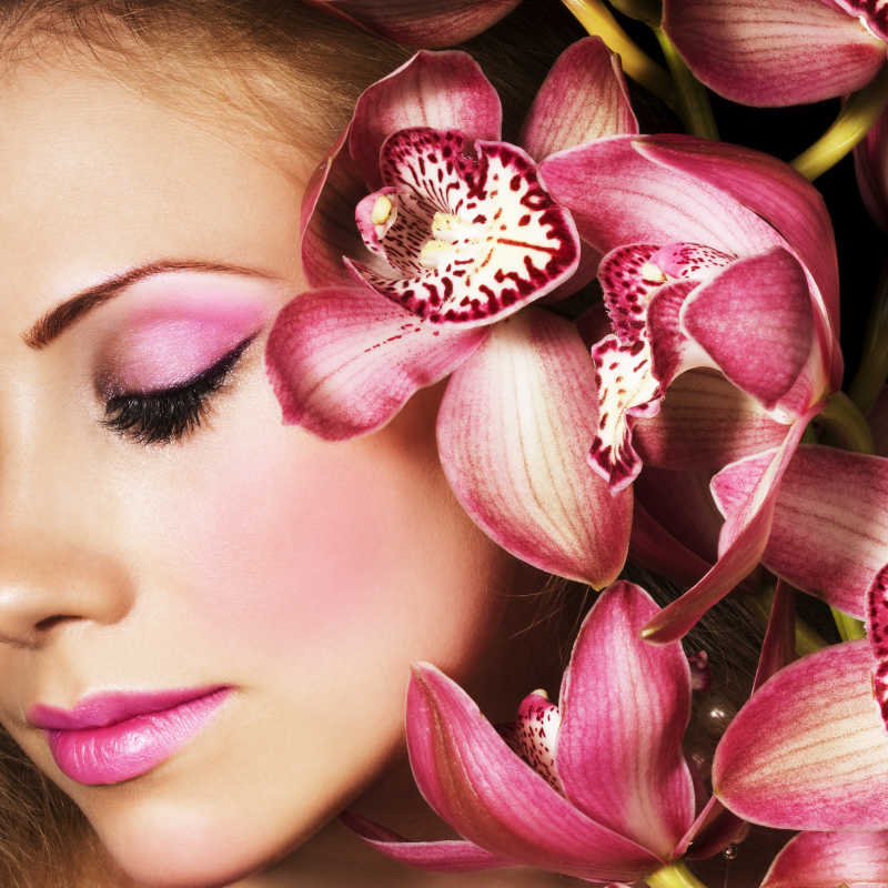 美女的脸和粉红色的兰花