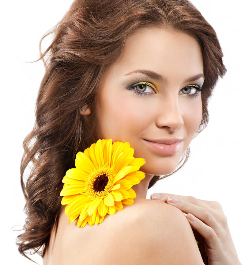 白色背景下手拿黄色菊花对着镜头微笑的美女