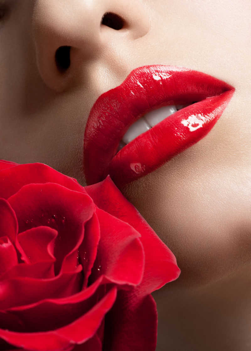 性感女人的红唇和美丽的红玫瑰