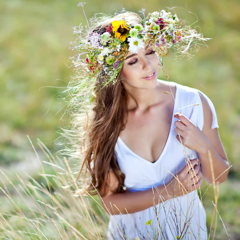 草地上戴着花朵的性感年轻女子
