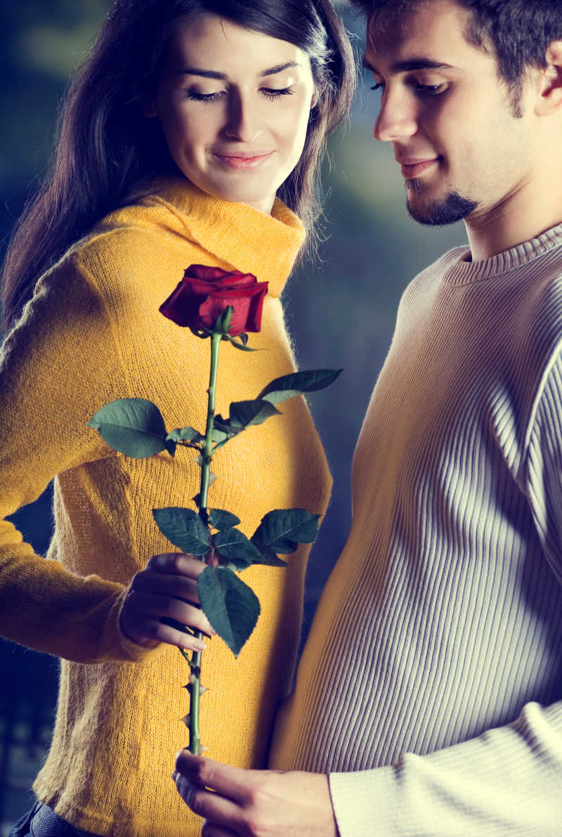 约会拿着玫瑰花的年轻情侣
