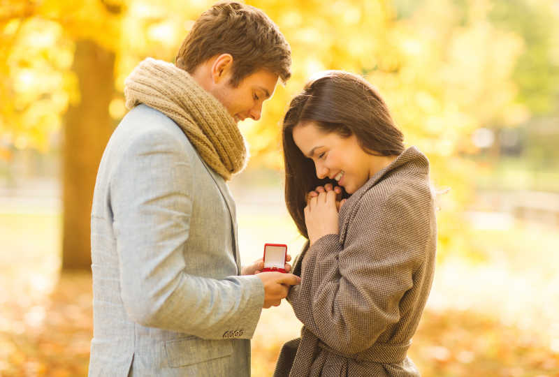 秋天公园里的求婚的幸福情侣
