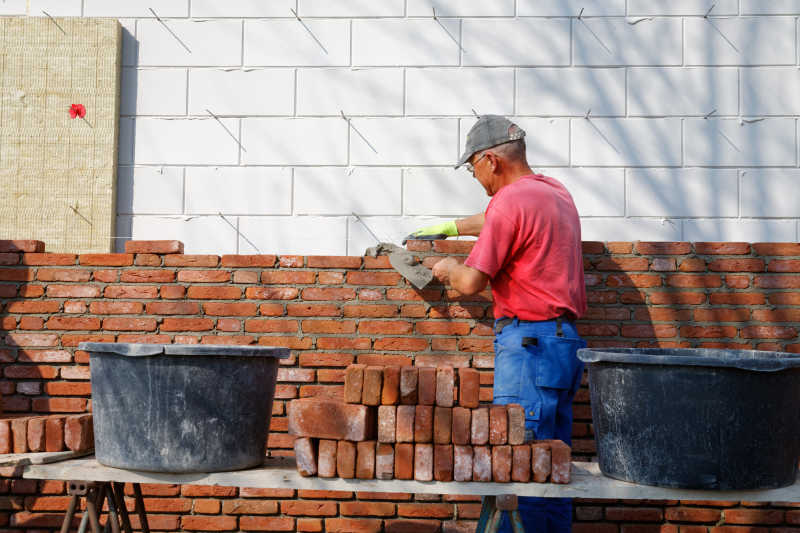 中年人砌墙建筑工人